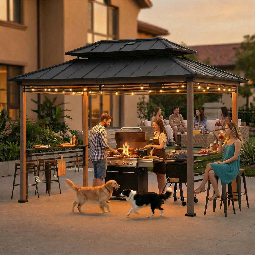 People gathered around a grill under a gazebo with two dogs in a backyard setting.
